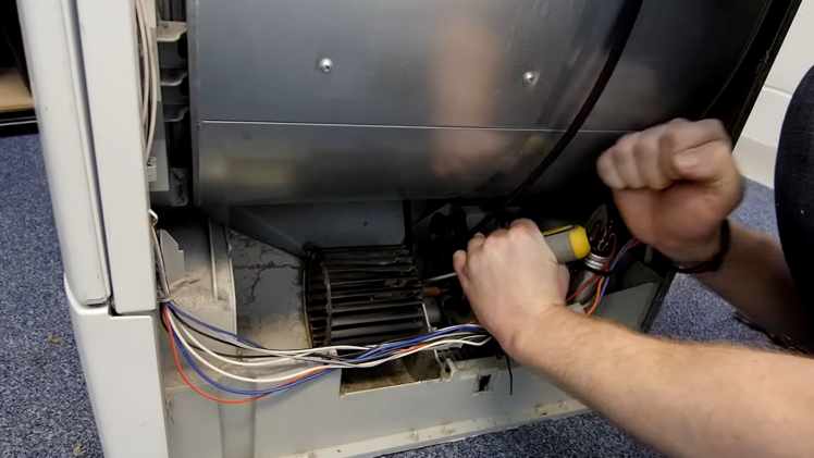 Dislodge the fan using a flat head screwdriver.