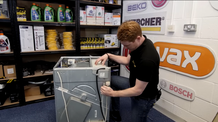 Disconnect the two hoses from the water container.