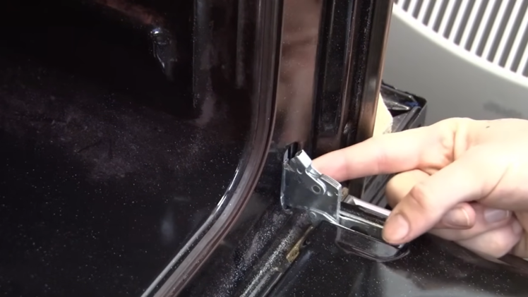 Open the latches on the oven door hinges.